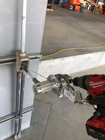 Electrician with the CP1000 Cordless Drill Powered Handheld Wire Puller home runs with jet line & the slotted extender arm with conduit clamp.